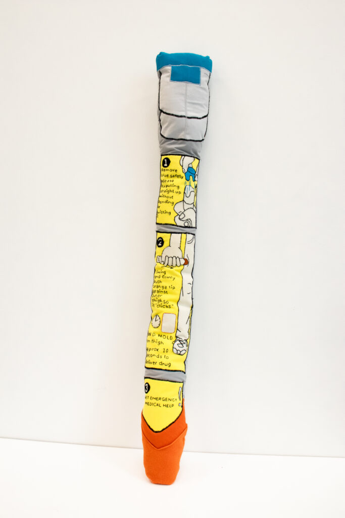 front view of soft sculpture epi-pen, balanced against white background