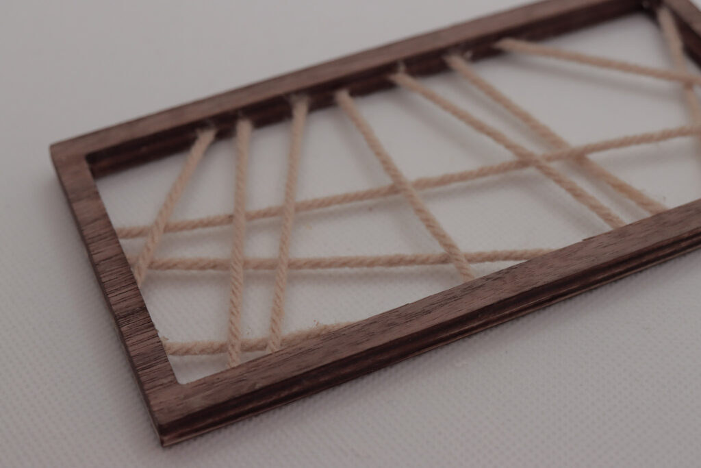 Wooden frame with string scattered inside 